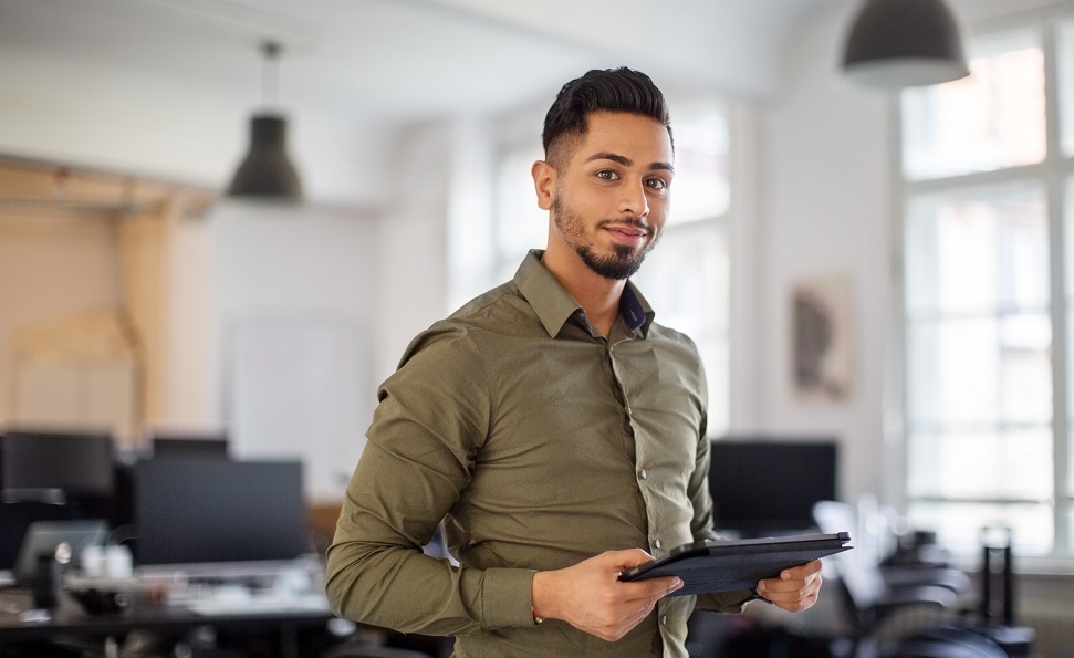 A man holding a tablet in an office | emerging tech roles