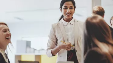 Smiling woman in a business meeting with colleagues.