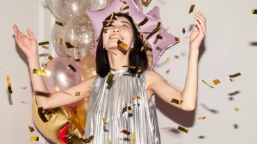 female person celebrating life, balloons, confetti